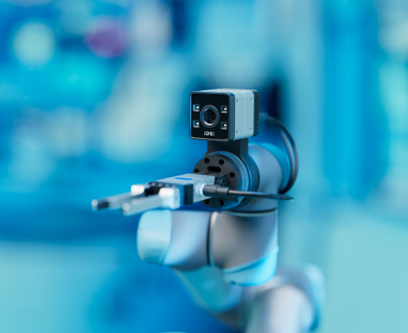 IDS ToF camera Nion on a gripper in front of a blue background