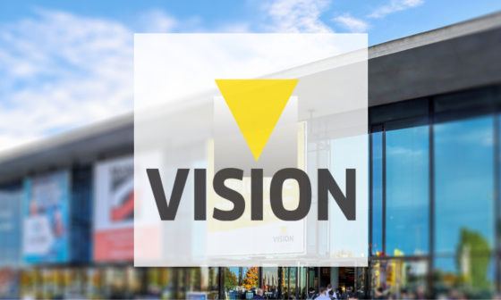 VISION logo in the foreground and exhibition hall in the background