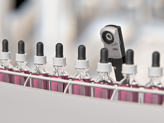 The uEye XC camera observes an assembly line producing containers of violet colour.
