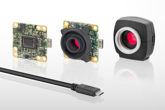 3 uEye LE camera with lenses and protective frame pointing to the right, with a cable in front of it
