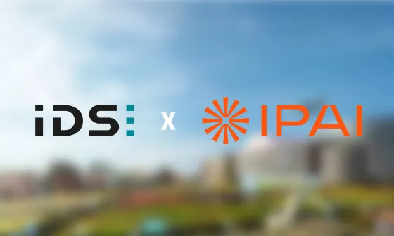The IDS and IPAI logos stand side by side. The vision of the IPAI campus can be seen in the background.