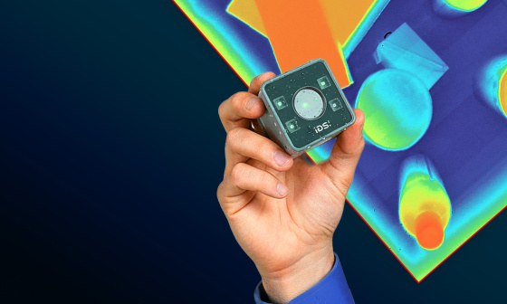 A hand on a blue background holding a Nion industrial camera