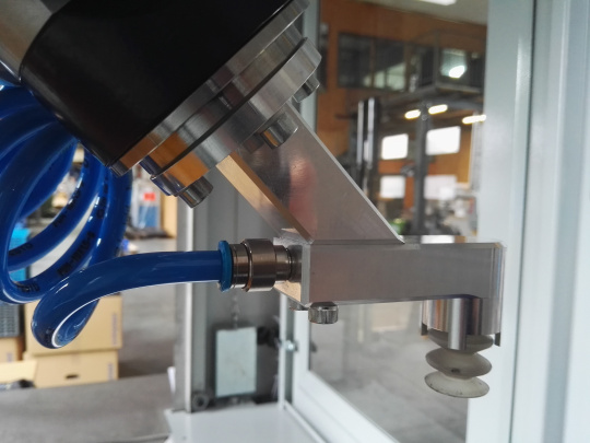 Robot arm in a robot cell with blue cable