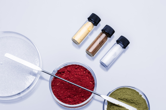Petri dishes and glass containers with material samples of various powders