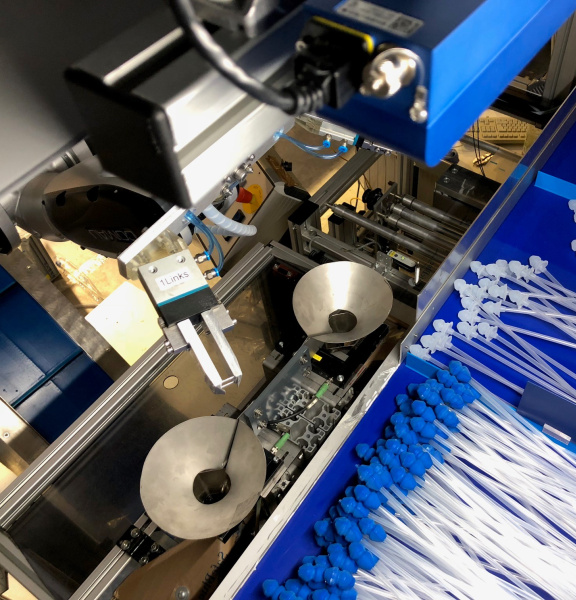 A robot sorts catheters with blue and white attachments using an Ensenso 3D camera.