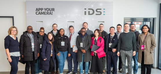 14-member MIT REAP delegation visiting IDS in front of a company wall