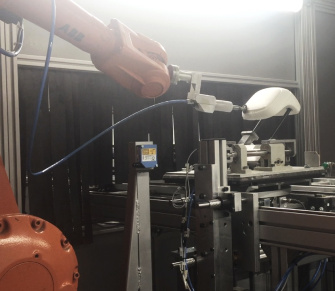 A robot cuts the foam to size with a grinding tool
