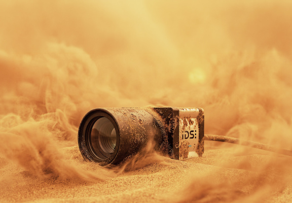 IDS industrial camera in sand amidst dust clouds
