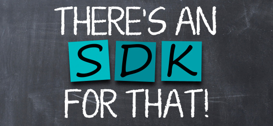 On a grey board is a white chalkboard with turquoise Post-Its on which S D K is written.