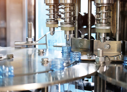 Machine automatically seals bottles in rotating gripper system