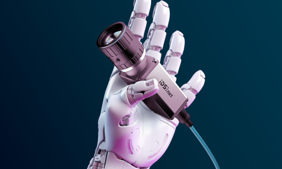 Robot hand holds an IDS NXT camera with cable