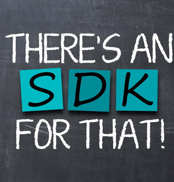On a grey board is a white chalkboard with turquoise Post-Its on which S D K is written.