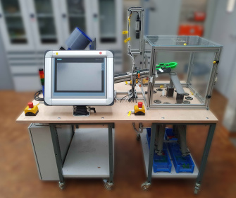 A sorting device is set up on a table, which sorts the clamping bricks by colour.
