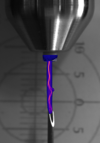A vertical, slender light trail beneath a metallic component, overlaid with colour