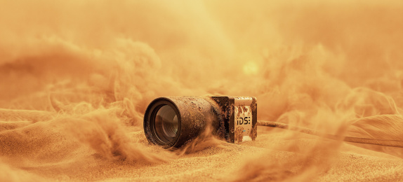 IDS industrial camera in sand amidst dust clouds