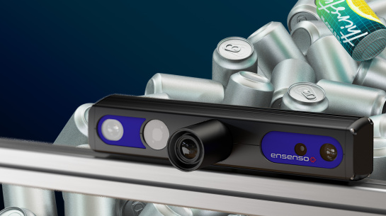 An Ensenso 3D camera is positioned in front of a pile of silver tins. One tin is coloured and labelled.