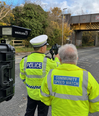 Police and assistants measure speed using Westcotec system and IDS camera at the roadside