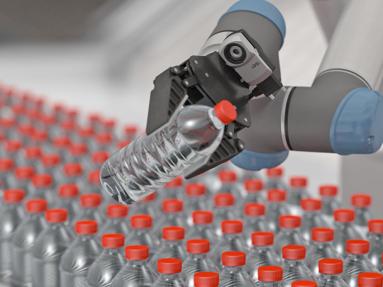 A robotic arm with uEye XC holds a water bottle with a red cap, with many more bottles in the background