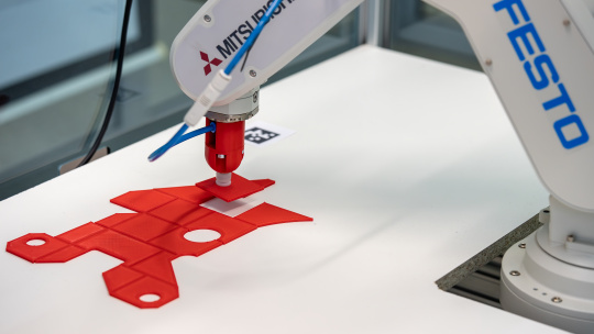 Robot arm places component at specified position.
