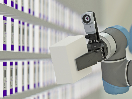 A robotic arm with uEye XC holds a parcel in front of a shelf with many other parcels.