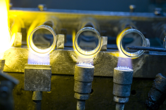 Three rolled rim bottles in production are heated from below