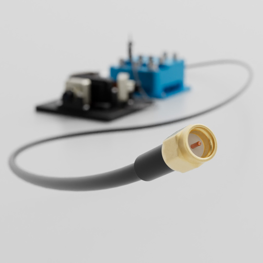 Gold-coloured coaxial plug and cable in front of a blurred circuit board